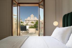 莱切莱切帕特里亚皇宫酒店的一间卧室设有一张床,享有阳台的景色