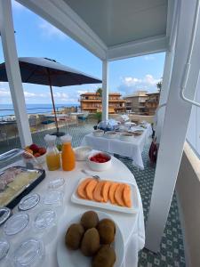 特罗佩阿NoOne Tropea Guesthouse的阳台上摆放着食物盘的桌子