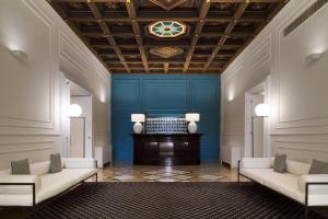 莱切莱切帕特里亚皇宫酒店的大堂设有2张白色沙发和1面蓝色的墙壁