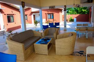 Abomey-CalaviRESIDENCE AINA的庭院配有柳条家具和桌椅