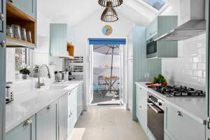 布里克瑟姆The Captain's Cottage, Brixham的厨房配有白色的柜台和蓝色的橱柜