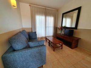 利乌玛Apartamentos Las Dunas-B的客厅配有蓝色的沙发和桌子