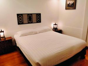 华欣BTC Hua Hin Home managed by BTC Boutique Resort的一张白色的床,房间有两个床头柜