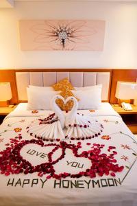 勒吉安The Sun Hotel & Spa Legian - CHSE Certified的一张床上有天鹅和鲜花的床