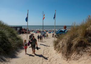 西姆斯科克Bed & Breakfast Bakker Meijer的一群人沿着海滩走