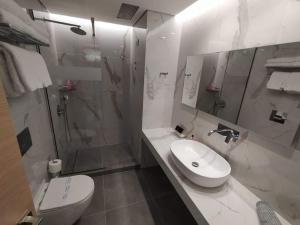 托隆弥诺阿酒店的浴室配有卫生间、盥洗盆和淋浴。