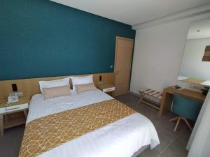 托隆弥诺阿酒店的一间卧室设有一张大床和蓝色的墙壁