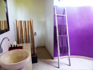 佩母德兰巴厘岛欧亚瑟度假酒店的一间带大浴缸和紫色墙壁的浴室