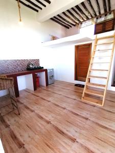 布韦朱New Arisen Bungalows的一间铺有木地板的客房和梯子