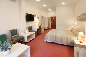 帕内韦日斯斯姆尔日内酒店的酒店客房带一张床、一张桌子和椅子