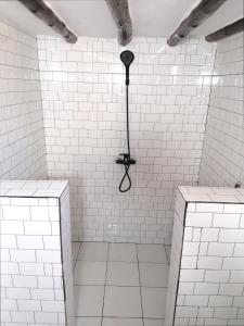 布韦朱New Arisen Bungalows的白色瓷砖淋浴和黑色雨伞