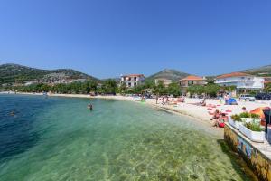 希杰弗朗吉卡Apartments with a parking space Seget Vranjica, Trogir - 8623的一群人一起在水中度过的海滩