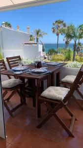 EsteponaEspectacular apartamento primera linea de playa - Golf的海景露台上的一张木桌和椅子