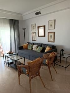 EsteponaEspectacular apartamento primera linea de playa - Golf的客厅配有蓝色的沙发和2张桌子