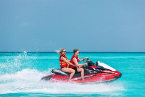 鲁阿环礁Heritance Aarah-Premium All Inclusive的两人在水中乘坐水上摩托艇