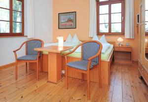 丹加斯特Pension Altes Posthaus的配有桌椅和床的房间