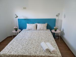 波尔图Enjoy Oporto Campanha 1的一间卧室配有蓝色床头板和一张带两张桌子的床