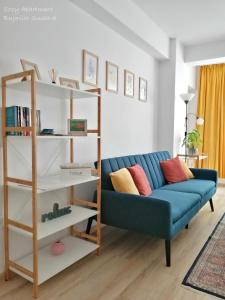 苏恰瓦Cozy Apartment Bujorilor Suceava的客厅设有蓝色的沙发和书架