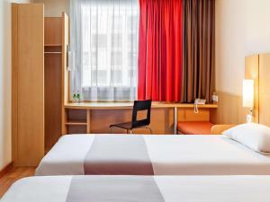 华沙华沙雷杜塔宜必思酒店的酒店客房配有两张床和一张书桌