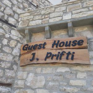 培拉特Guest House J.Prifti的砖墙上的一个标牌读j