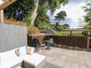 莫尔德Primrose Cottage的庭院配有白色沙发和遮阳伞。