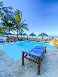 普瓦尼梅查恩加尼Villa Thamani Zanzibar的棕榈树和海洋度假村的游泳池