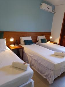 伦索伊斯Pousada Casa Viva a Vida的酒店客房,设有两张床和两张桌子
