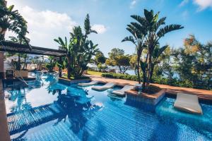圣蓬萨Iberostar Selection Jardín del Sol Suites - Adults Only的一个带躺椅的游泳池,棕榈树