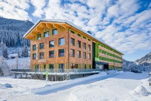 法尔先特Explorer Hotel Garmisch的山前的雪中酒店