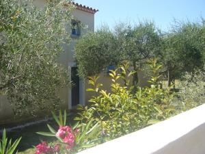 ArgilliersApartment Uzès Pont du Gard的一座花园,位于一座种有树木和鲜花的建筑前