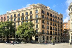巴塞罗那科隆巴塞罗那酒店的一座大型建筑,前面的人在步行