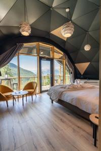 莱索尔Alpin D'Hôme Hôtel & Spa的一间卧室设有一张大床和大窗户