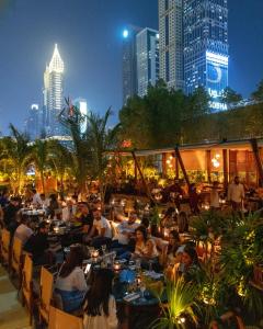 迪拜Jumeirah Emirates Towers Dubai的一群坐在餐厅桌子上的人