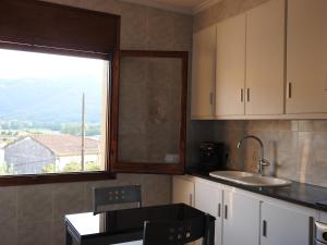 巴斯Precioso apartamento con sauna y terraza的一间厨房,配有白色的橱柜和大窗户