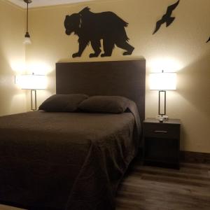 兰德Frontier Lodge的卧室在床上方设有熊雕像
