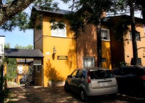 科隆Puerto Escondido的停在黄色房子前面的汽车