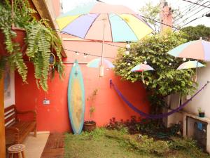 圣保罗MADÁ hostel的墙上有雨伞和冲浪板的房子