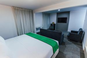 利马Hotel Hacienda Lima Norte的配有一张床和一把椅子的酒店客房