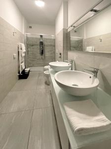 乌尔比诺天堂住宿加早餐旅馆的白色的浴室设有2个盥洗盆和淋浴。