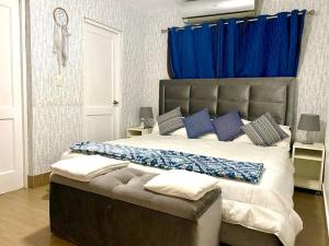 圣多明各Casa con Parqueo Privado, Patio y Jacuzzi.的一间卧室配有一张带蓝色窗帘的大床