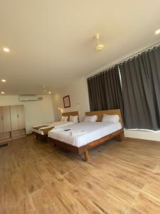 斯里卡拉哈斯蒂Hotel Bluestone的一间卧室设有一张大床和一个大窗户