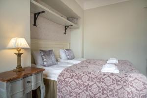 塔林Dream Stay - Historical 3-Bedroom Apartment with Sauna & Fireplace的一间卧室配有一张床和一张带台灯的桌子