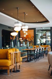 斯希丹Van der Valk Hotel Schiedam的一间带桌椅的餐厅和一间酒吧