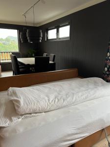 弗莱克菲尤尔Feriehus i Flekkefjord med panoramautsikt的卧室配有白色的床和桌椅
