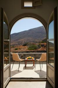 伊亚Danae Suites Santorini的阳台享有房屋的景致,配有桌椅