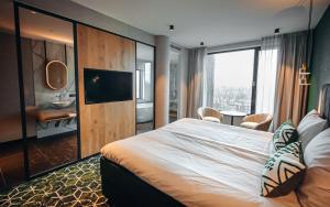 斯希丹Van der Valk Hotel Schiedam的酒店客房设有一张大床和一台电视。