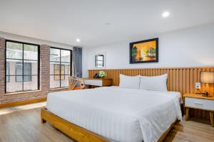 岘港Flexi Hotel & Apartment的卧室设有白色大床和窗户。