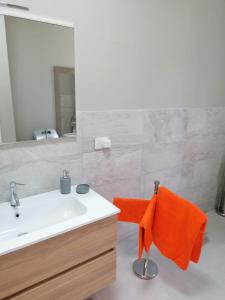 西维尔诺瓦·马尔凯Sea 1的浴室设有水槽、镜子和橙色毛巾