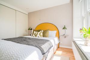 伦敦Be London - The Covent Garden Residences的一间卧室配有一张大床和橙色大床头板