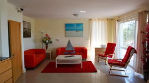 瓦尔纳Вила Сънрайз - Villa Sunrise的客厅配有2把红色椅子和桌子